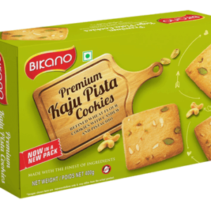Green Bikano box of Premium Kaju Pista Cookies with a wooden cutting-board label and scattered cookies on the box design. - Bikano Kaju Pista Cookies 200 Gms